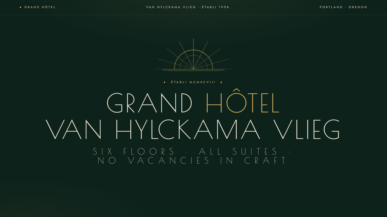 Grand Hôtel van Hylckama Vlieg — art deco hotel façade with gold sunburst marquee on bottle green, Poiret One lettering